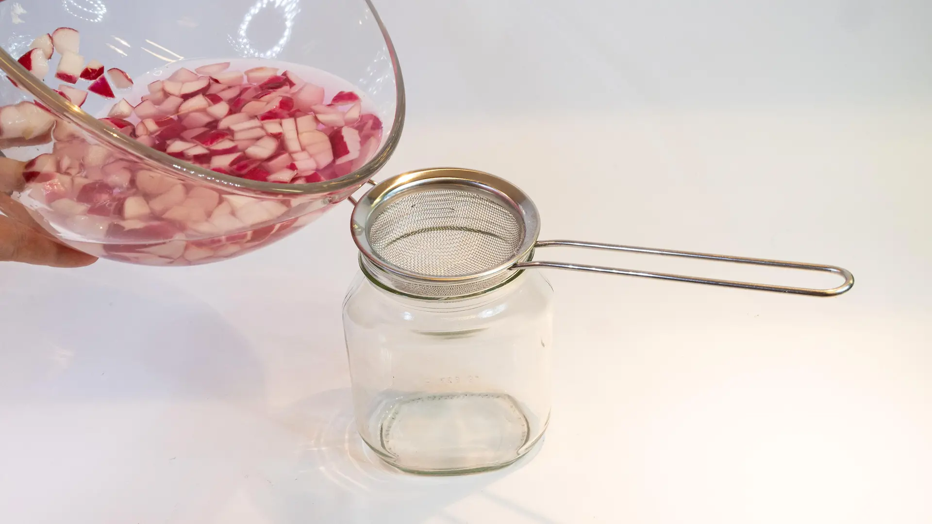 el jugo de rábano se vierte a través del tamiz en un vaso